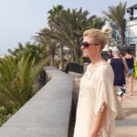 Woman on a walkway looking out over palm trees
